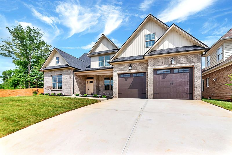 Brick and board-and-batten exterior with a concrete drive