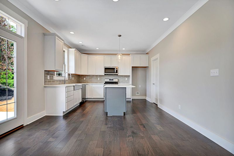 Open kitchen with white cabinets and a gray island