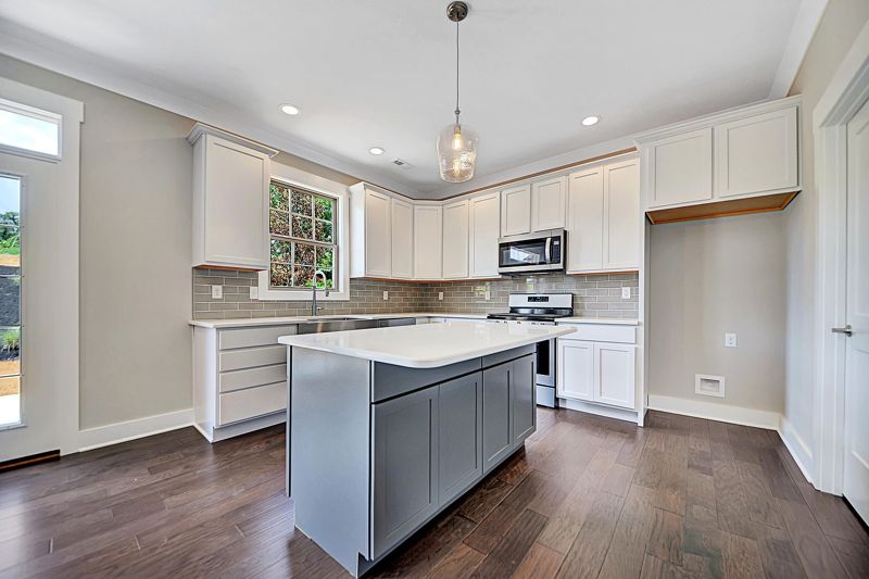 Kitchen island with pendant lighting and stainless appliances