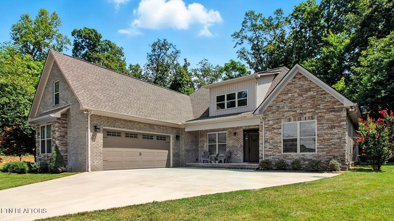 Front exterior of a brick and stone custom home with gabled rooflines