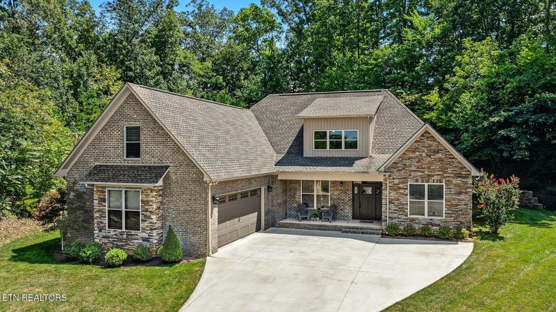 Brick and stone custom home with a two-car garage and concrete drive