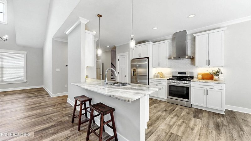 Kitchen with a large island, white cabinets and bar seating