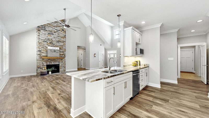Kitchen and great room with stone fireplace beyond