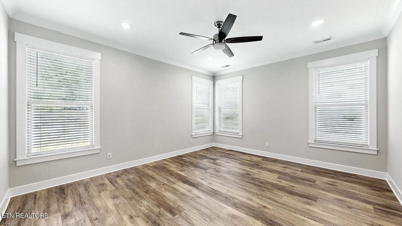 Primary bedroom with tray ceiling and ceiling fan