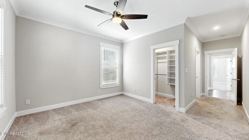 Bedroom with ceiling fan and large windows