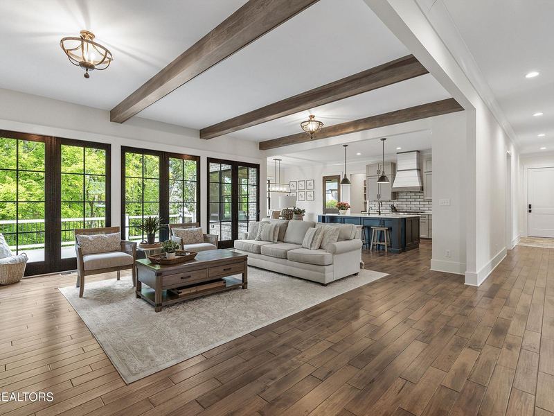 Great room with exposed beams and black-framed windows