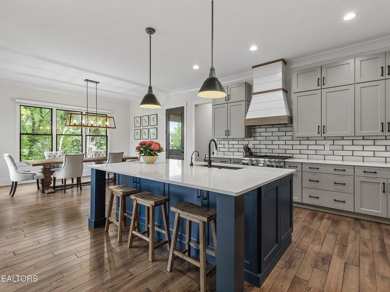 Kitchen with navy island and pendant lights